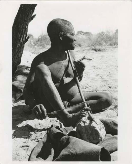 "Music": Oukwane seated, playing a bow (print is a cropped image)