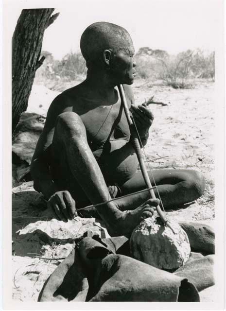 "Music": Oukwane seated, playing a bow (print is a cropped image)