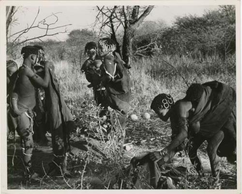 "Move": Group preparing to leave Gautscha for a hunting and gathering trip, including //Kushay (second wife of "Gao Helmet", headman of Band 2), Xama (Gao's daughter with his first wife) with bead ornaments in her hair, Khuan//a (daughter of "Old /Gaishay and Di//khao, //Kushay's sister) leaning over (print is a cropped image)