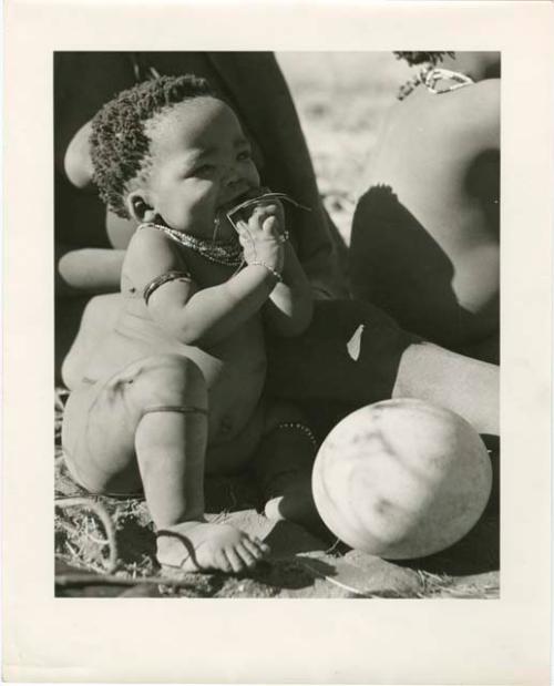 "Mongolian spot": Baby sitting next to an ostrich eggshell (print is a cropped image)