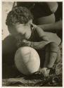 "Ostrich egg shell": Baby (child of ≠Gao, leader of Band 10, and Bau, his first wife) sitting next to an ostrich eggshell (print is a cropped image)