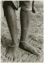 "Ornaments & beads": Metal rings on ankles, bead and grass bracelets under knee (print is a cropped image)