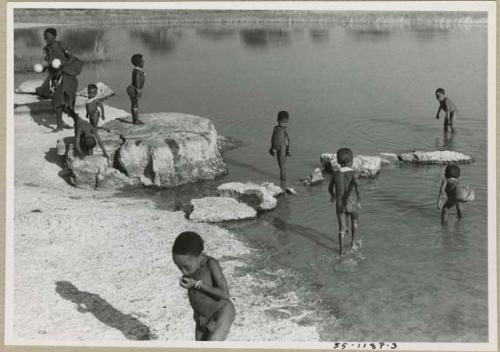 "Pan": Children playing in the water and people on the shore (print is a cropped image)