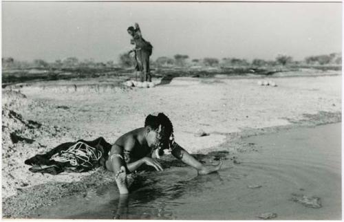 "Pan": Girl bathing with an unidentified woman in the background (print is a cropped image)