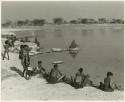 "Pan": Group of women and children beside the water; N!ai is picking up Debe (print is a cropped image)