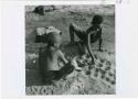 [No folder title]: Two boys playing /Ui (the counting game) in the sand, view from above (print is a cropped image)