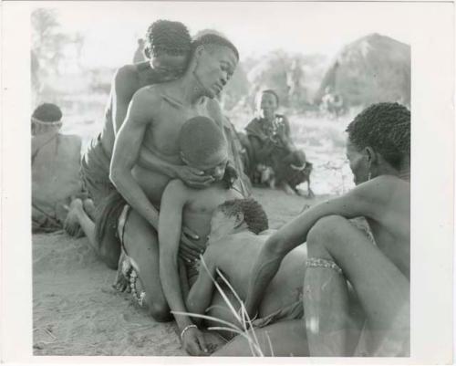 [No folder title]: Four men collapsed in trance after aiding /Gunda, at a daytime dance (print is a cropped image)