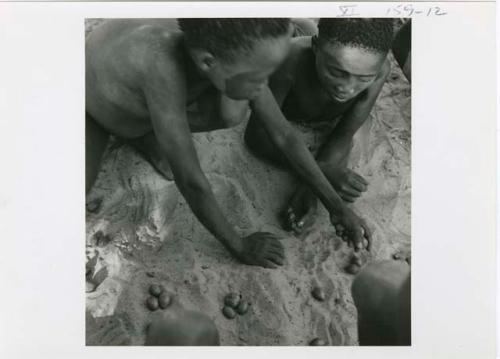 [No folder title]: Two boys playing /Ui (the counting game) with a group of boys (print is a cropped image)