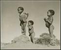 "Physical characteristics, including boys": /Gaishay (son of "Gao Medicine" and Di!ai), Bau (daughter of "Crooked /Qui"), and "Little ≠Gao" (son of "/Qui Navel") standing on an ant hill (print is a cropped image)