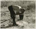 Man washing his face in a bucket