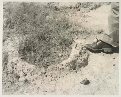 Casper Kruger standing next to a pits and a rock formation near the Herero Reservation, close-up