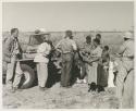 Group of people standing around the expedition Jeep with William Donnellan, Robert Story, John Marshall and Lorna Marshall