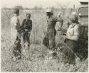 /Gunda (!Nai's husband) standing near expedition truck with Kernel Ledimo, Elizabeth Marshall Thomas and John Marshall