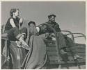 Philip Hameva, Heinrich Neumann and Elizabeth Marshall Thomas sitting on the top of an expedition truck