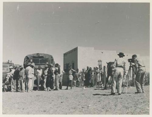 Groups of people and trucks at a trading post