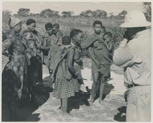 Group of people talking with L. F. Maingard, with Laurence Marshall photographing them