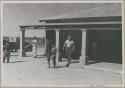 Theunis Berger leaving a store, and people walking in front of it