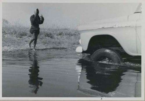 Kernel Ledimo guiding an expedition vehicle (Chevrolet) as it crosses the Muzwamo River
