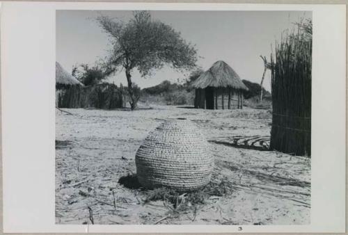 Basket, with huts in background