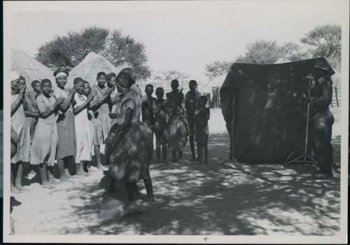 Group of women clapping and singing, being recorded