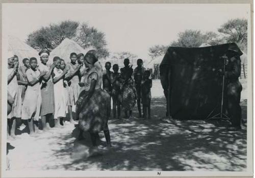 Group of women clapping and singing, being recorded