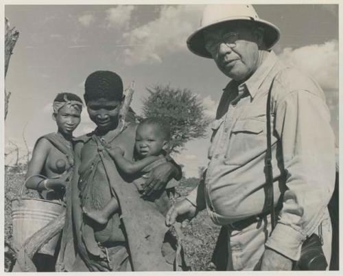 Two women standing with Laurence Marshall, one is holding a baby