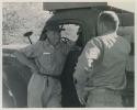 Thomas Hardbattle talking to William Donnellan next to an expedition truck