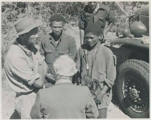 Group of people talking with L. F. Maingard, preparation for a recording