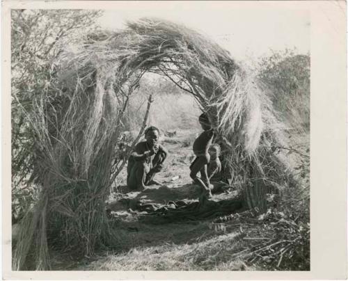 "Living places, shelters": Bo (brother of /Naoka, first wife of "Gao Medicine") sitting with his children in a skerm built for shade in hot weather (print is a cropped image)