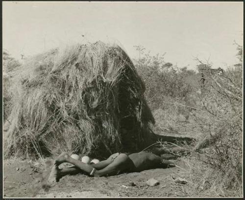 "Living places, shelters": Man sleeping next to a skerm (print is a cropped image)