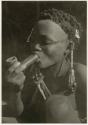 "Smoking": Bau smoking a soapstone pipe (print is a cropped image)