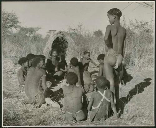 [No folder title]: Group of men and boys playing a game, including "Gao Medicine," "Old Naishi" (headman of Band 5), and "≠Gao Lame" (standing) (print is a cropped image)