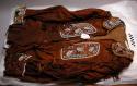 Brown buckskin jacket, beaded with fringe on sleeves, 4 buttons on front.