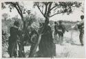 [No folder title]: Group of women performing a menstruation ceremony, Nicholas England standing to the right with sound recording equipment (print is a cropped image)