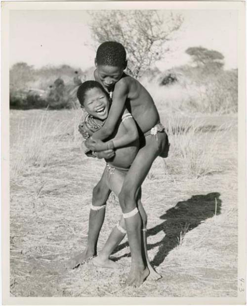 "Children in groups": Gao (son of ≠Gao and Khwo//o-/Gasa) standing with his arms around another boy (print is a cropped image)