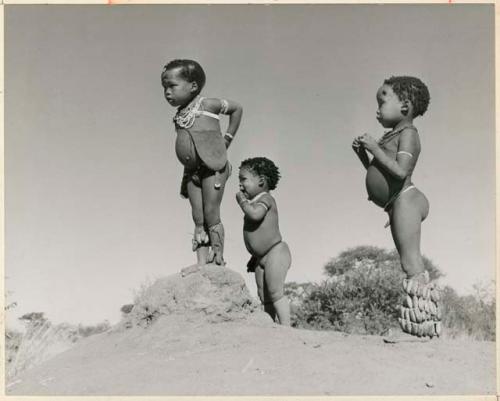 "Children in groups": /Gaishay (son of "Gao Medicine" and Di!ai), Bau (daughter of "Crooked /Qui"), and "Little ≠Gao" (son of "/Qui Navel") standing on an ant hill (print is a cropped image)