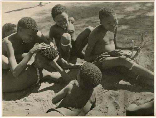 "Children in groups": /Gaishay ("Gao Medicine" and Naoka's son) delousing "≠Gao Lame," with /Gishay (son of "Old Gau") watching, ≠Toma (son of Gau) playing a //guashi (print is a cropped image)