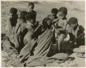 "Children in groups": Group of people sitting around a fire, including /Naoka ("Gao Medicine's" first wife), her son /Gaishay, "≠Gao Lame," and Gao (son of ≠Gao and Khwo//o-/Gasa) (print is a cropped image)