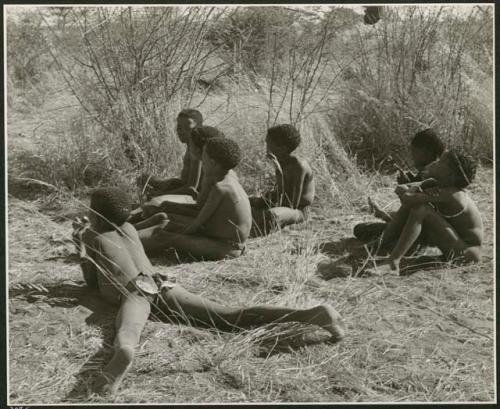 "Boys Groups, playing //guashi": Boys sitting at the edge of the cleared patch, watching girls dance (print is a cropped image)