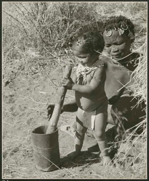 "≠Toma's sister !Ungka from Kai Kai, Her da. [daughter] Sa≠gai, she is wife of /Ga[i]shay": !Ungka (≠Toma's sister) and her daughter, Sa≠gai, who is playing with a mortar and pestle (print is a cropped image)