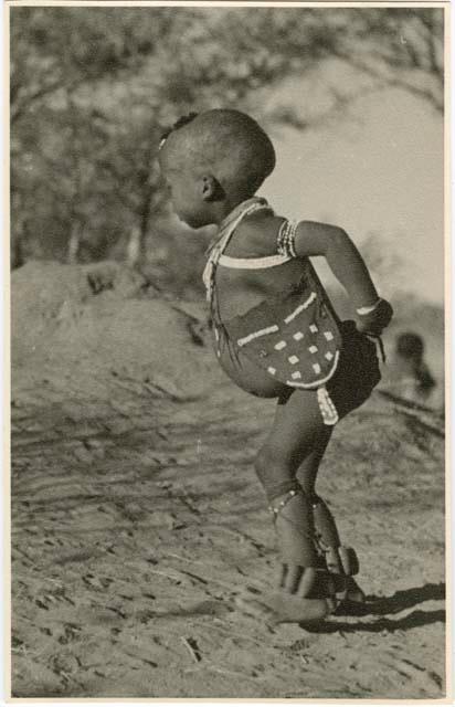 [No folder title]: /Gaishay playing a stick-throwing game, wearing beads, a bag, and dance rattles (print is a cropped image)