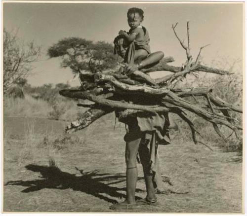 "Carrying children": /Goishay carrying wood, with her baby on her shoulder (print is a cropped image)