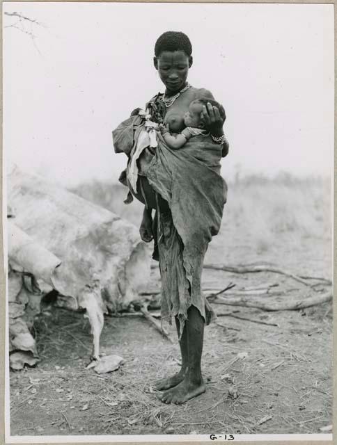 "Carrying children": !U standing, with Norna tied to her side, side view (print is a cropped image)