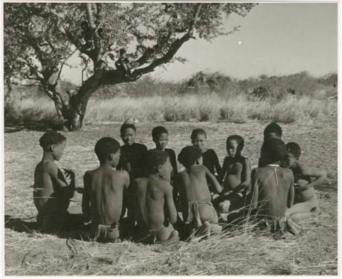 "Porcupine or Axe and Assegai [game]": Group of men and boys playing !ó'm!hú / !’Om g!xuni / ’Ai kota !U!u g!xuni / N!aih //’an (the porcupine game, also known as the axe game, assegai game or war game), including "≠Gao Lame," /Gunda with a feather, ≠Gao (son of Gau and Be of Band 2) and Tsamgao (son of ≠Toma, Band 1) (print is a cropped image)