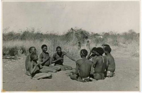 "Porcupine or Axe and Assegai [game]": Men and boys playing !ó'm!hú / !’Om g!xuni / ’Ai kota !U!u g!xuni / N!aih //’an (the porcupine game, also known as the axe game, assegai game or war game) (print is a cropped image)