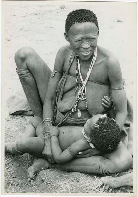 "Nursing": Khuan//a (Gau's second wife) sitting on the ground and an unidentified child in her lap (print is a cropped image)