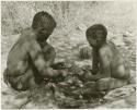 Oukwane and an unidentified boy working on a kaross (print is a cropped image)