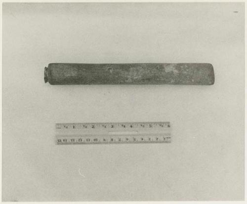 Oukwane's implement for scraping hides, a stick with a small blade inserted in the end, with a ruler for measurement (print is a cropped image)