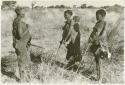 Three women standing in their veld, holding their digging sticks (print is a cropped image)