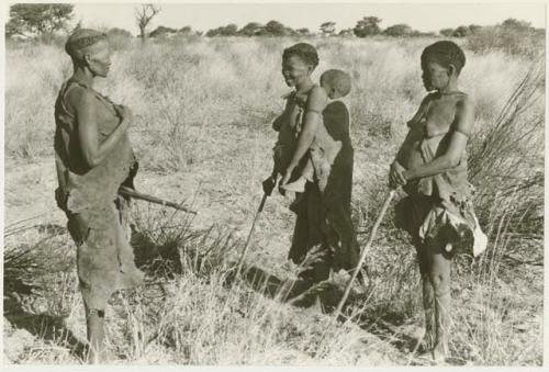 Three women standing in their veld, holding their digging sticks (print is a cropped image)